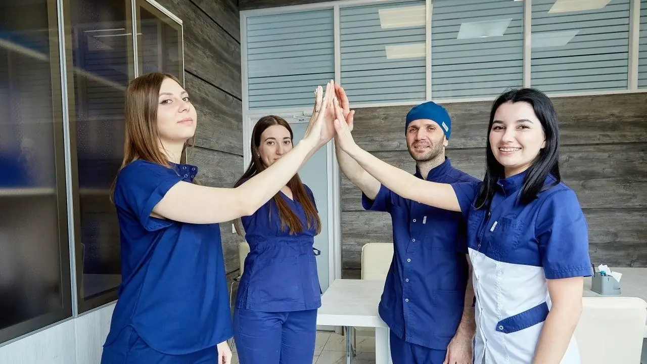 Врачи и ассистенты стоматологического центра 32 Clinic дают друг другу пять